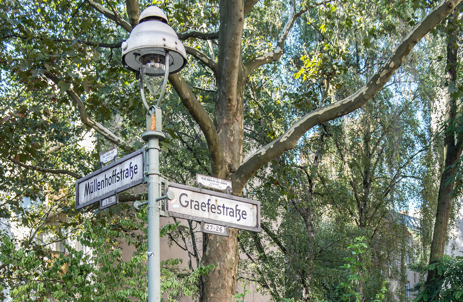 Streetlamp with the streetsign of Graefestraße and Müllenhofstraße attached, with a tree in the background. One of Berlin's premier Ramen joints has moved to the neighbourhood, will there be something new to eat on the menu as well?
