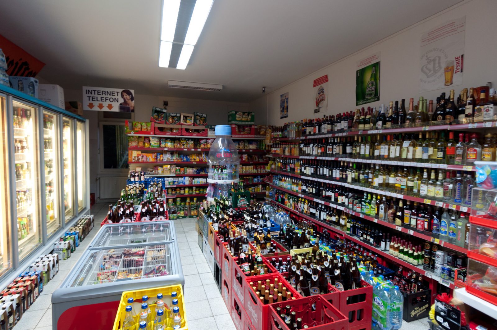 The inside of a typical Berlin späti or Spätkauf, filled with shelves full of bottles of wine, beer, juice, and lemonades. 