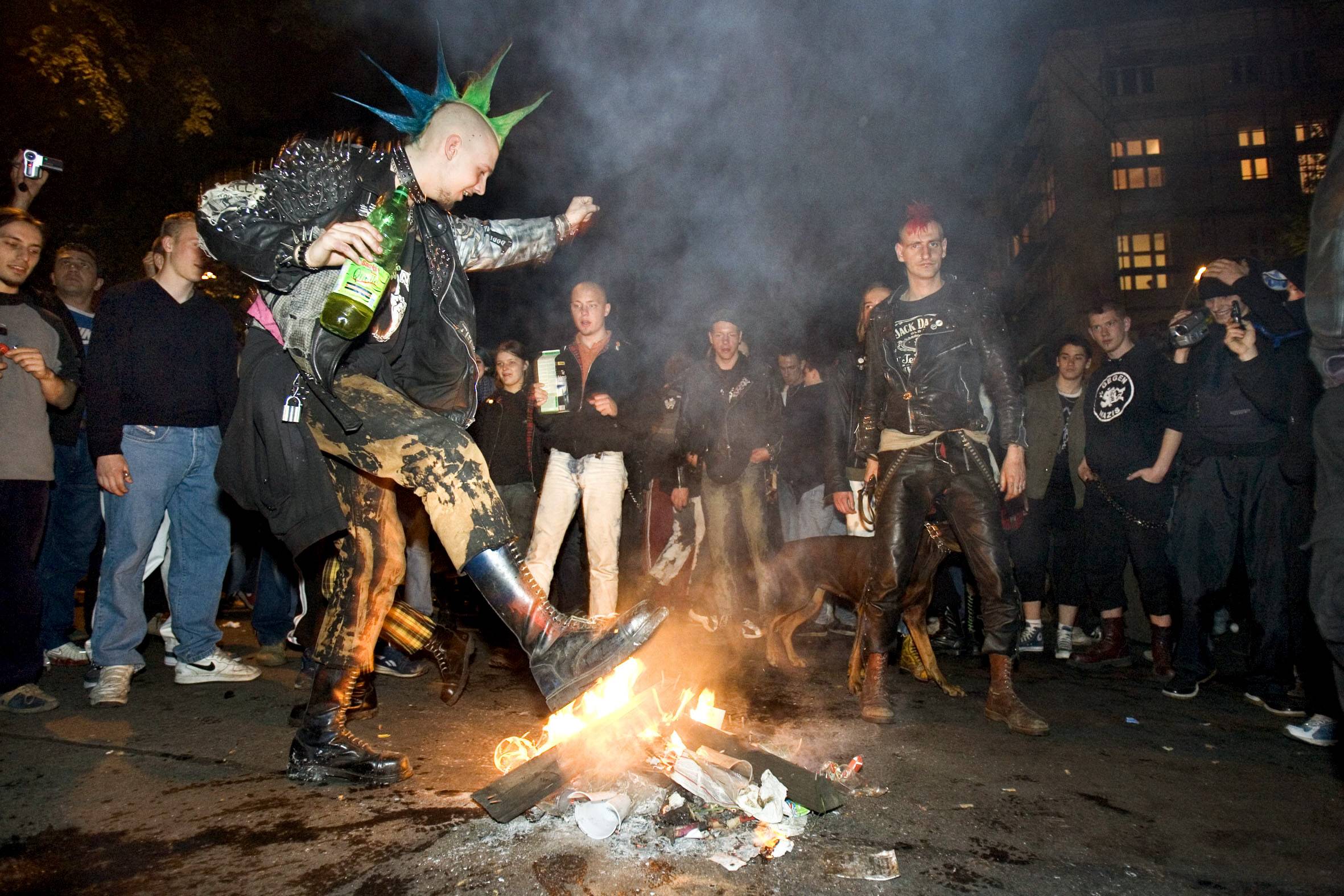 Ein Punk tanzt um ein Feuer bei der Walpurgisnacht in Friedrichshain.