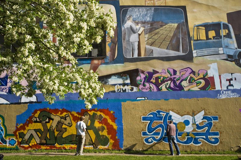legal sprayen in Berlin Sprayer begutachten ihre Kunstwerke an der linken Seite des Tommy-Weissbecker-Hauses in Kreuzberg.