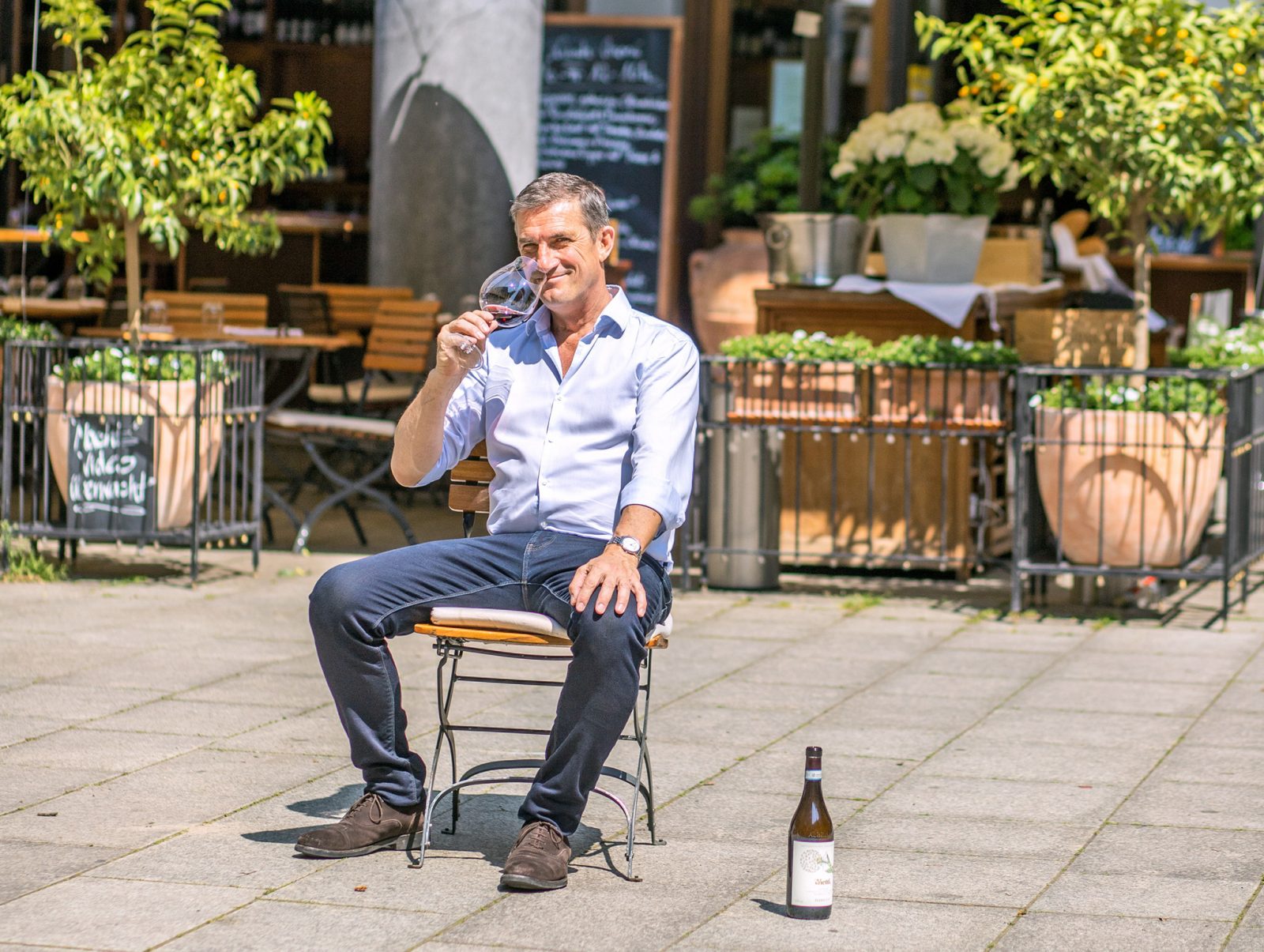 Der Chef macht's vor: Antonio Bragato zeigt auf unserem Foto selbst, wie man im Il Calice den Sommer genießt. Er sitzt mit einem Glas Wein auf einem Stuhl auf dem Platz. Trinken in der Sonne und am Wasser