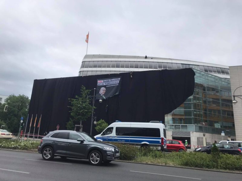 In den Morgenstunden des 1. Juli lassen Aktivisten von Extinction Rebellion ein Transparent vom Dach der CDU-Zentrale in Tiergarten