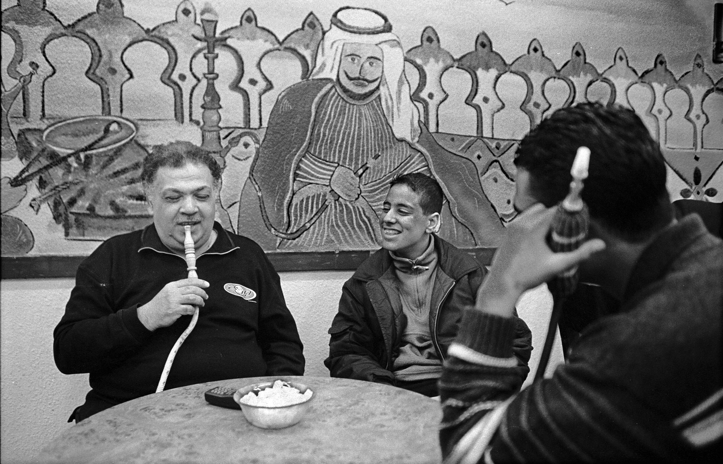 Männer rauchen in einem arabischen Café gemeinsam Shisha. 