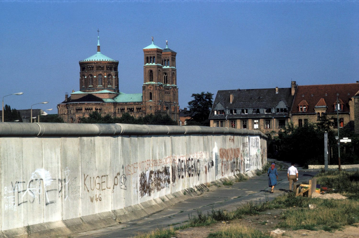 Spaziergang durch Kreuzberg: Für das Paar im Bild ist die Berliner Mauer Alltag. Foto: imago images / Günter Schneider
