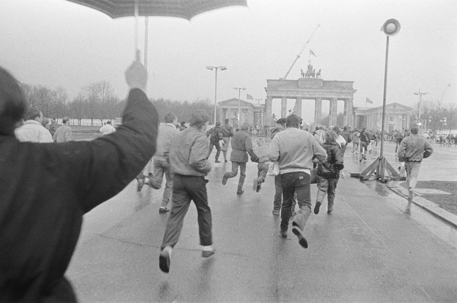 Menschen laufen, nach Öffnung der Mauer am 22.12.89, auf das Brandenburger Tor zu, 1989. Foto: Harald Hauswald