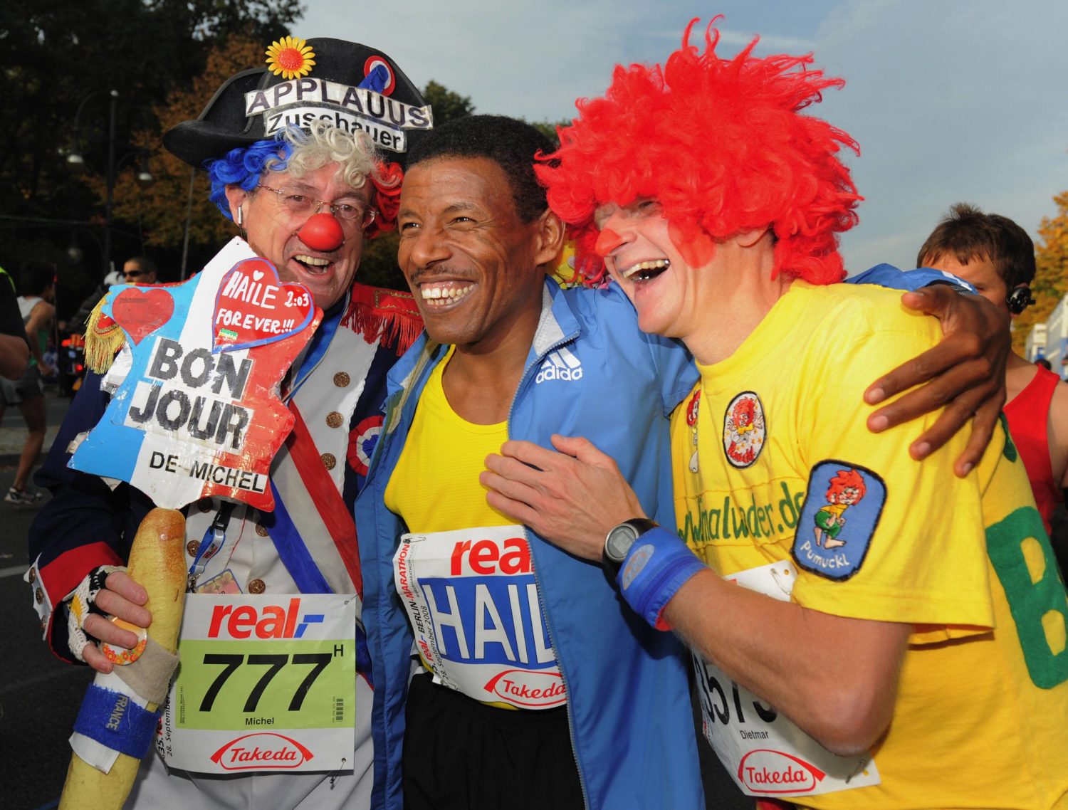 Haile Gebrselassie (Äthiopien, Mitte) feiert seinen Sieg beim Berlin Marathon 2008 mit zwei Clowns. Foto: Imago/Camera4