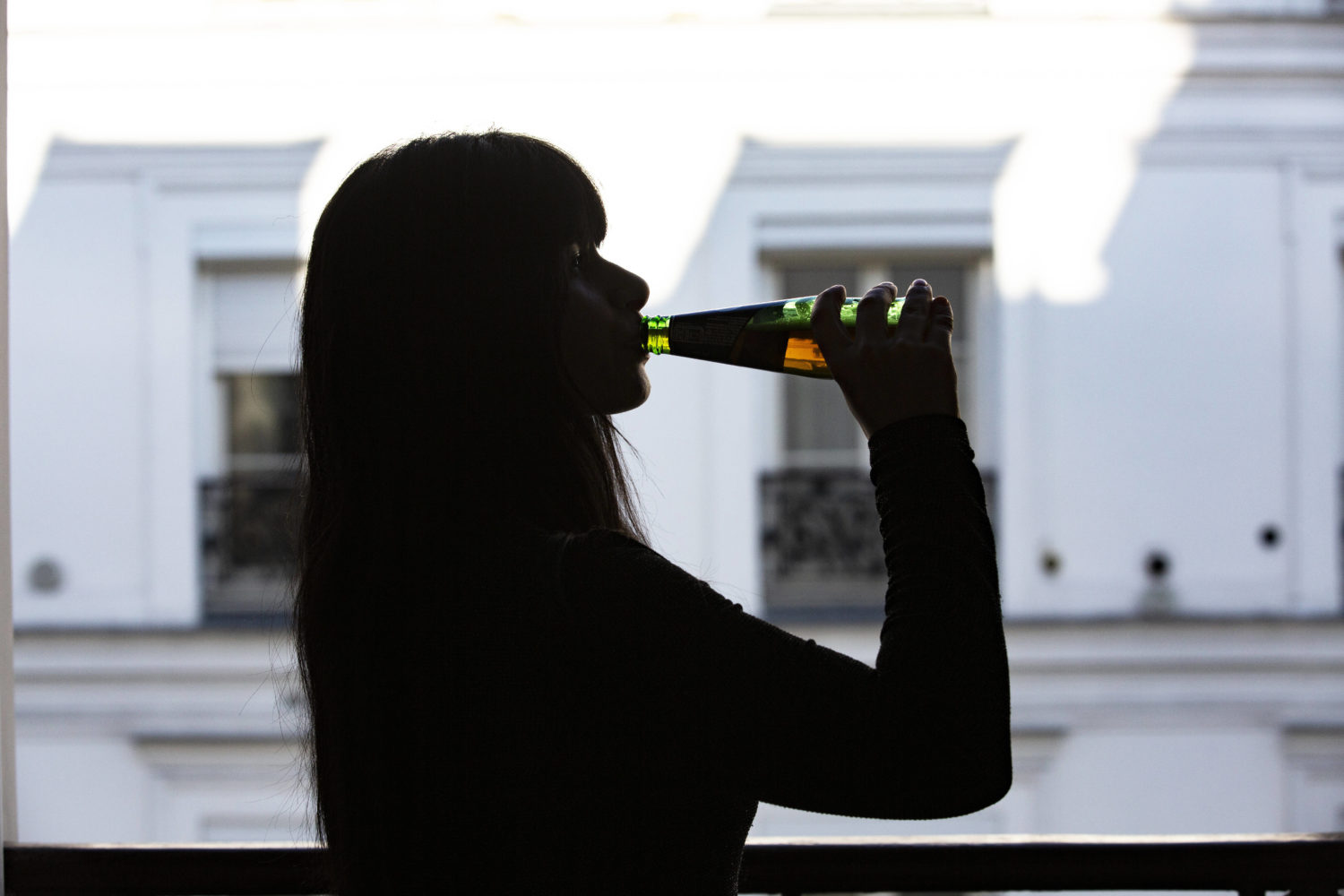 Schatten einer Frau, die ein Bier trinkt. 