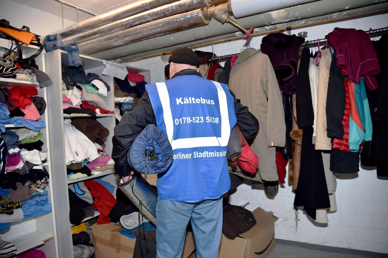 Obdachlosen helfen in Berlin: Spendenübergabe einer Kleiderkammer an einen Mitarbeiter des Kältebusses. Foto: Imago Images/Revierfoto