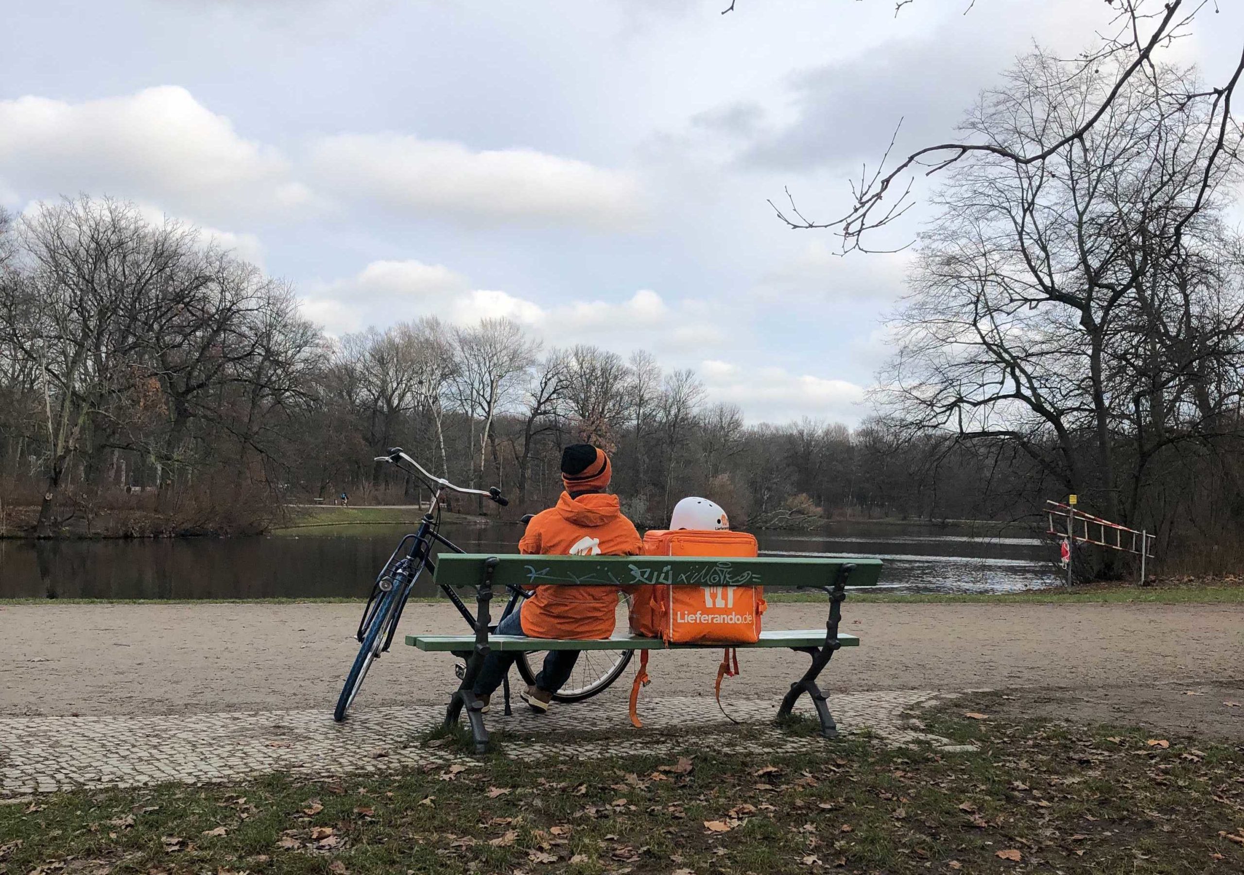 Warten im Park: ein Lieferant des Lieferdienstes Lieferando legt eine Pause im Park ein.      Lieferdienste in Berlin