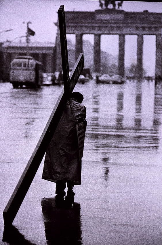 Historische Berlin Fotos: Ein bedrückendes Bild, eine alte Frau trägt ein Kreuz Richtung Brandenburger Tor, die Aufnahme entstand im Oktober 1961, wenige Wochen nach dem Mauerbau. Foto: Toni Frissell Collection/Library of Congress