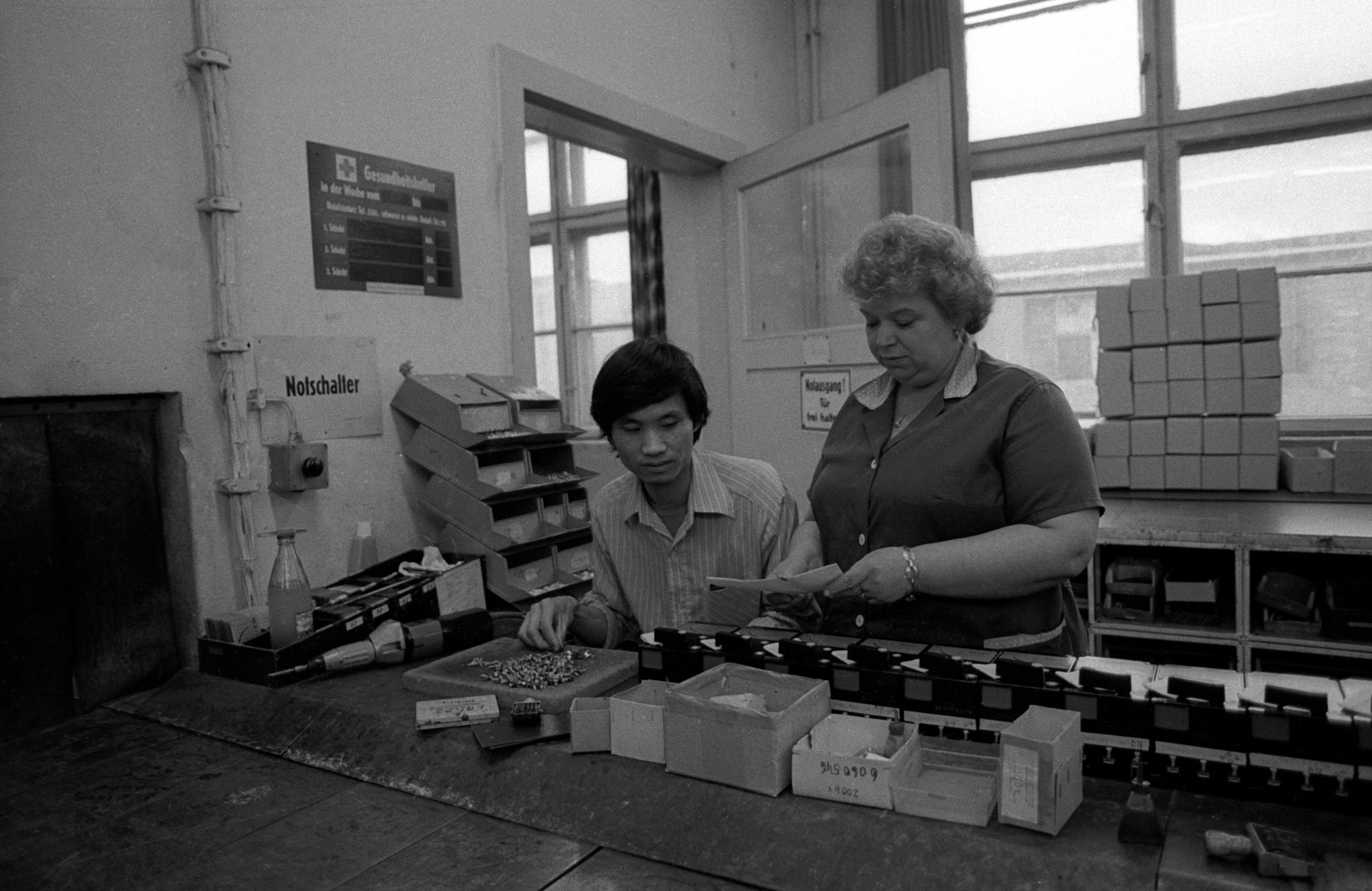Vietnamesischer Vertragsarbeiter in den Werkshallen eines Volkseigenen Betriebes in Ost-Berlin um 1990.  Foto: Imago/Werner Schulze 