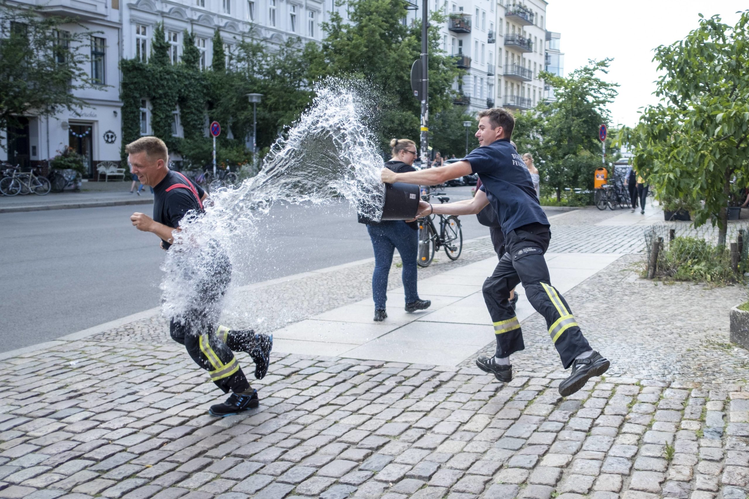 Feuerwehrleute der Feuerwache in der Oderberger Straße in Prenzlauer Berg verpassen einem Kollegen eine Wasserdusche. Foto: Imago/Snapshot