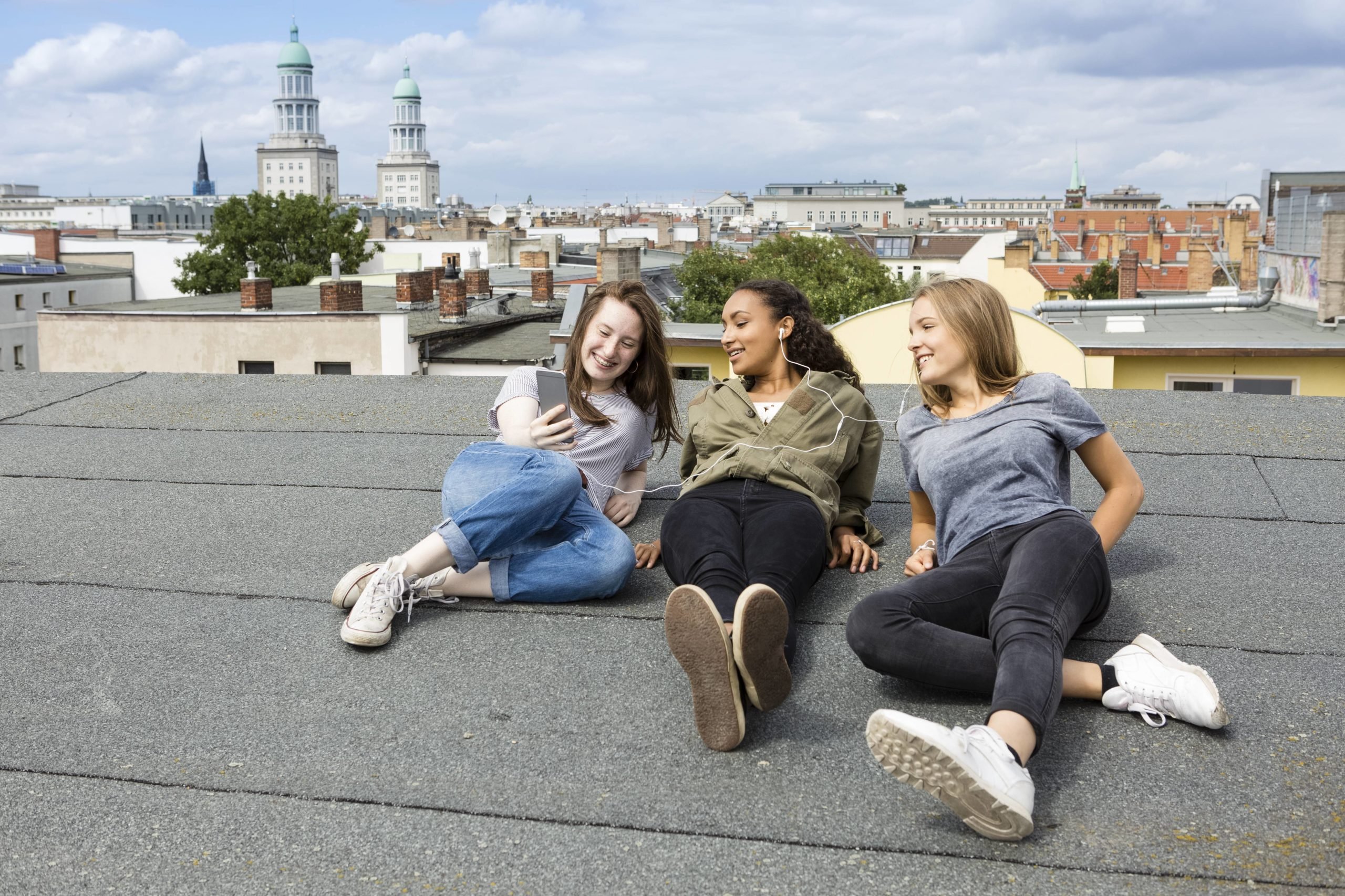 Dächer über Berlin: Junge Frauen entspannen auf dem Dach eines Hauses in Friedrichshain. Foto: Imago/Westend61