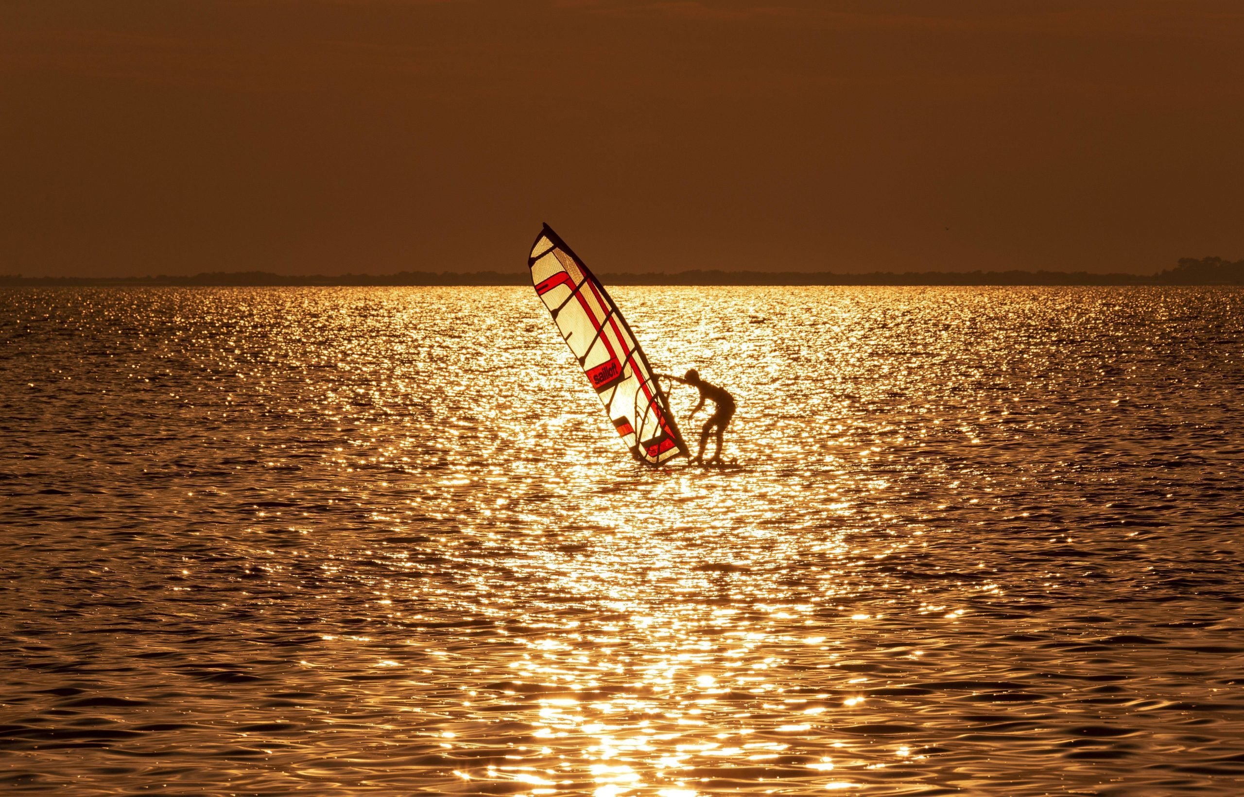 Rügen Mit dem Segel übers Meer: Das Rügen Surfhostel in Ummanz bietet Wind- und Kitesurf-kurse für Einsteiger:innen und Aufsteiger:innen an.