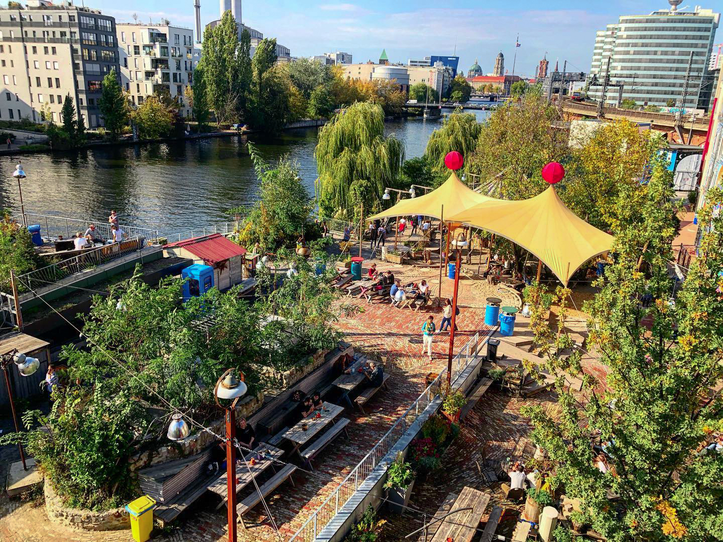 Spielplatz für Erwachsene: der Holzmarkt 25 mit der Spree im Bild Trinken in der Sonne und am Wasser
