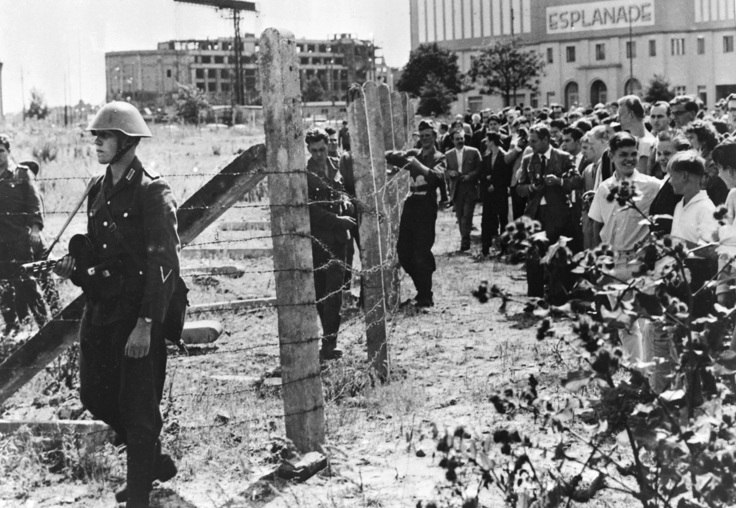 13. August 1961: West-Berliner versammeln sich an der Grenze und schauen DDR-Grenzsoldaten bei den Bauarbeiten an neuen Grenzabsperrungen zwischen den beiden Teilen der Stadt zu. Foto: Imago/United Archives International