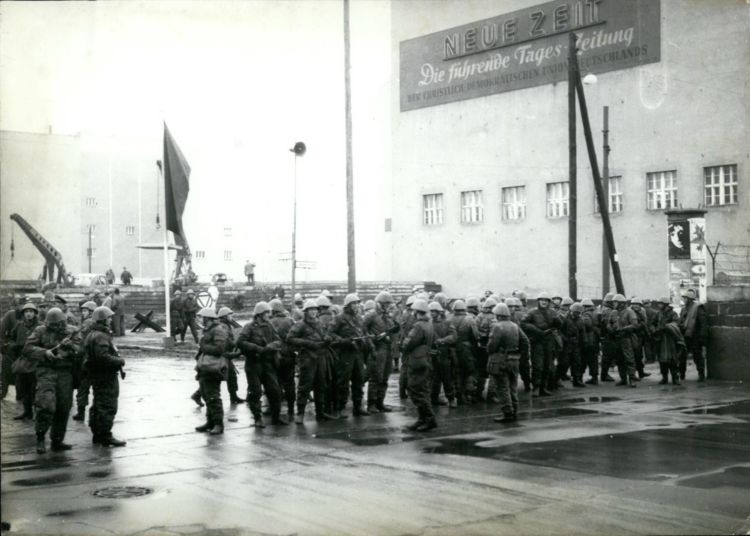 12. Dezember 1961: Soldaten der Volksarmee stehen an der Grenze am Grenzübergang Friedrichstraße, dahinter sind Baumaßnahmen an der Berliner Mauer zu erkennen. Foto: Imago/ZUMA/Keystone