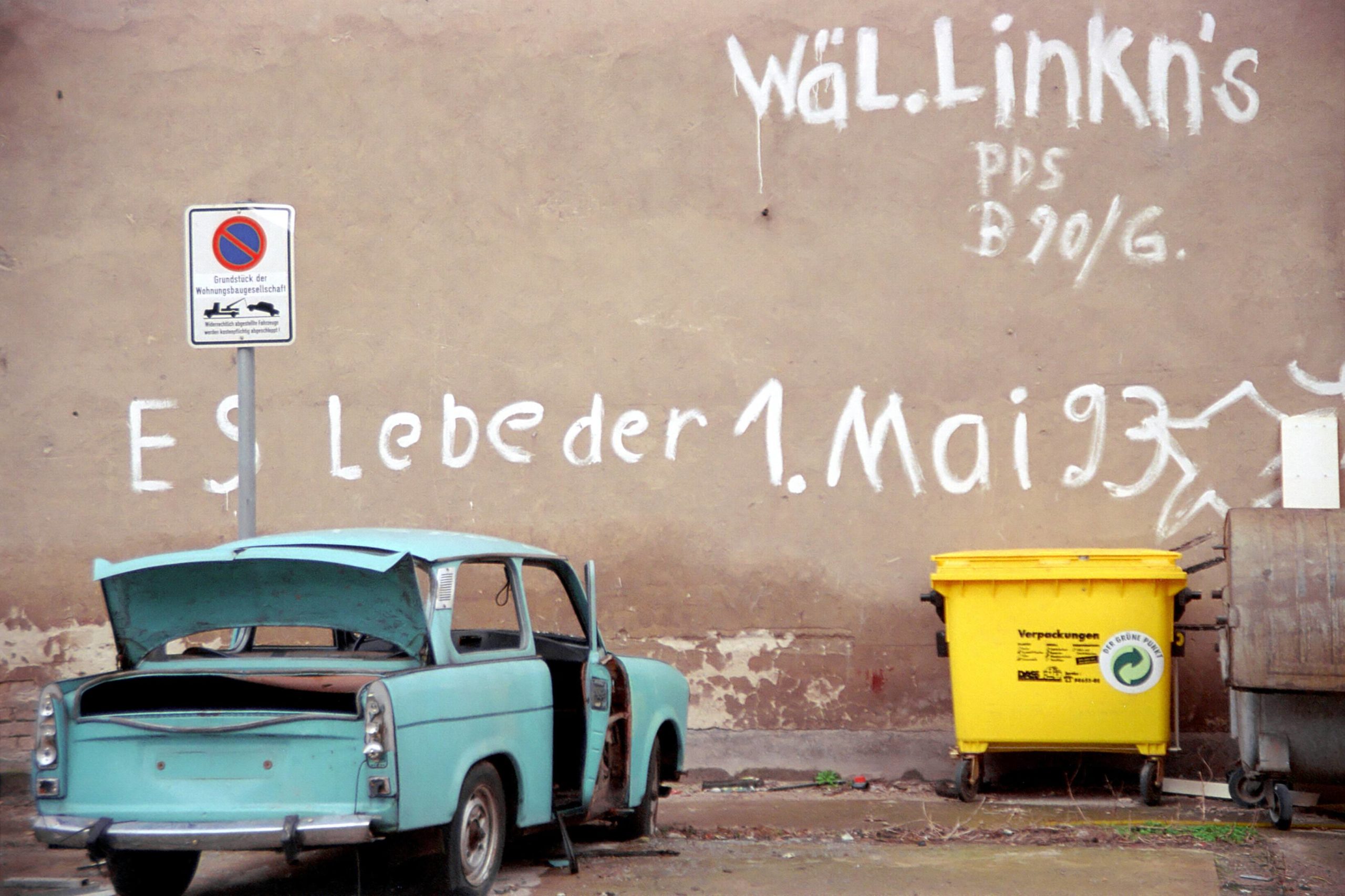 Parole "Es lebe der 1. Mai" an einer Hauswand und Trabileiche, 1995. Foto: Imago/Rüttimann