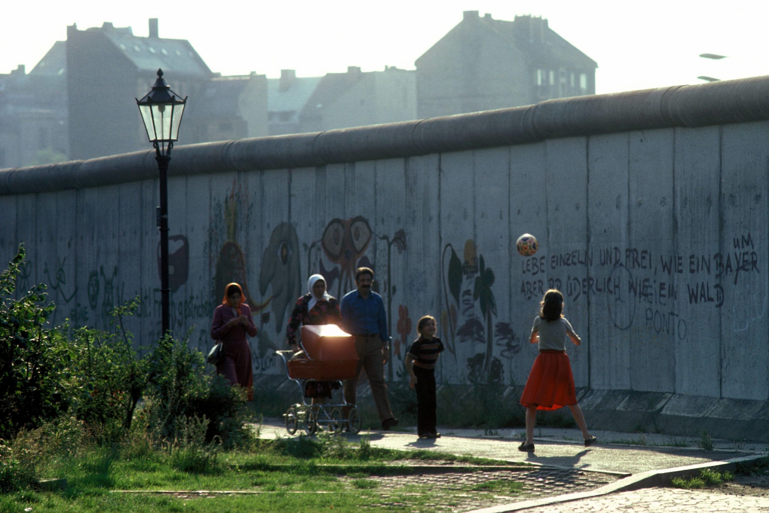 Türkische Familie spaziert an der Berliner Mauer in Kreuzberg. Foto: Imago/Günter Schneider