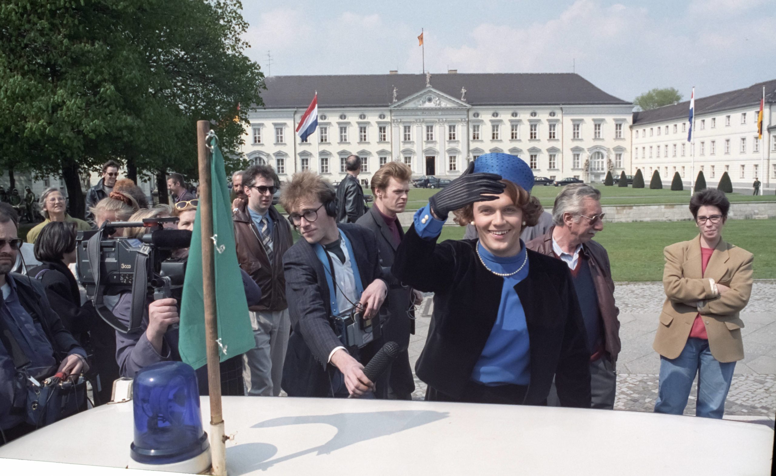 Hape Kerkeling winkt am 25. April 1991 als Königin Beatrix der Niederlande verkleidet vor dem Schloss Bellevue in Berlin. Foto: Imago/Jürgen Schwarz