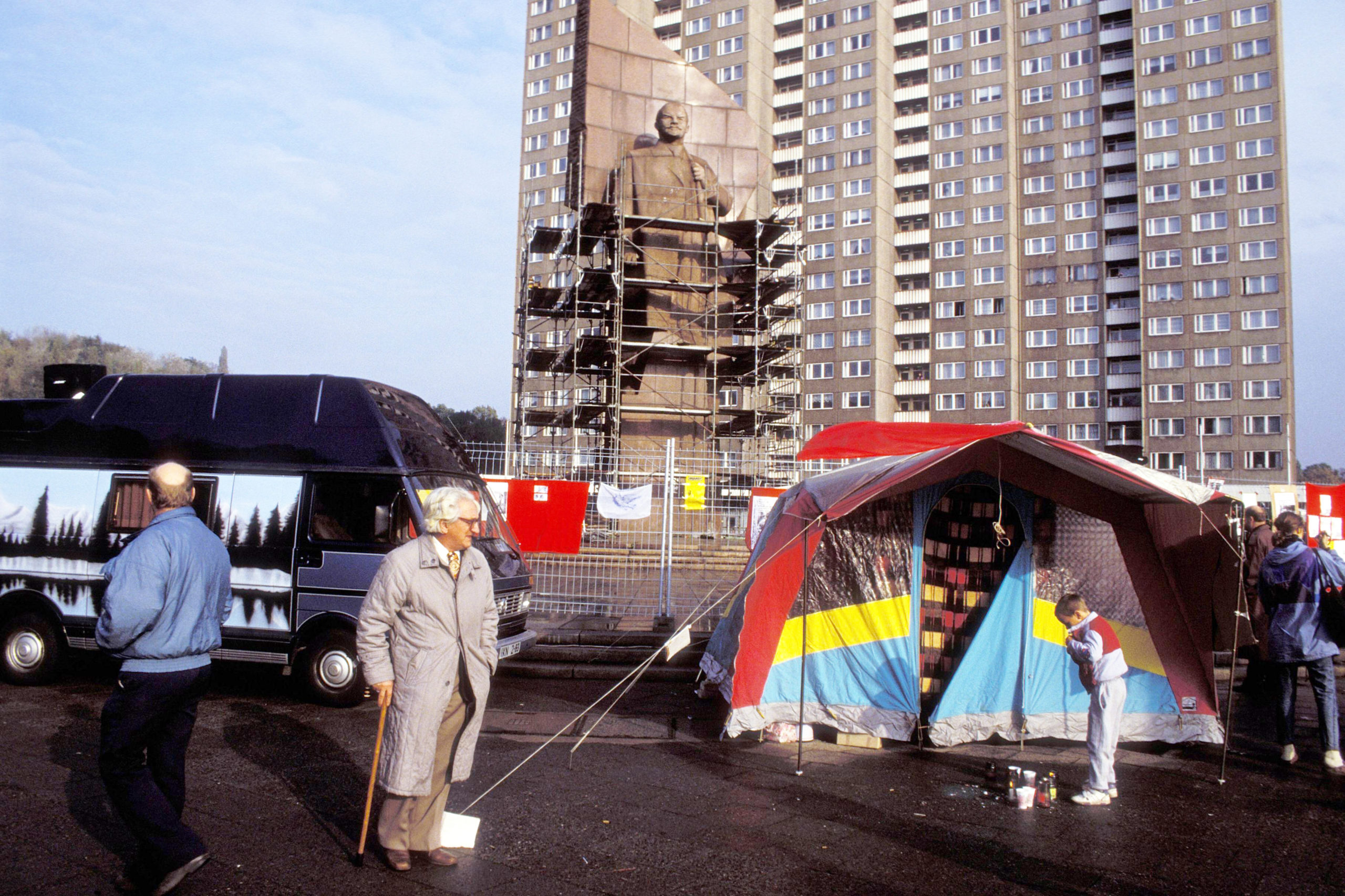 Passanten vor dem Zelt eines Demonstranten während des Protestes gegen den Abriss des Lenindenkmals am Leninplatz, November 1991. Foto: Imago/PEMAX