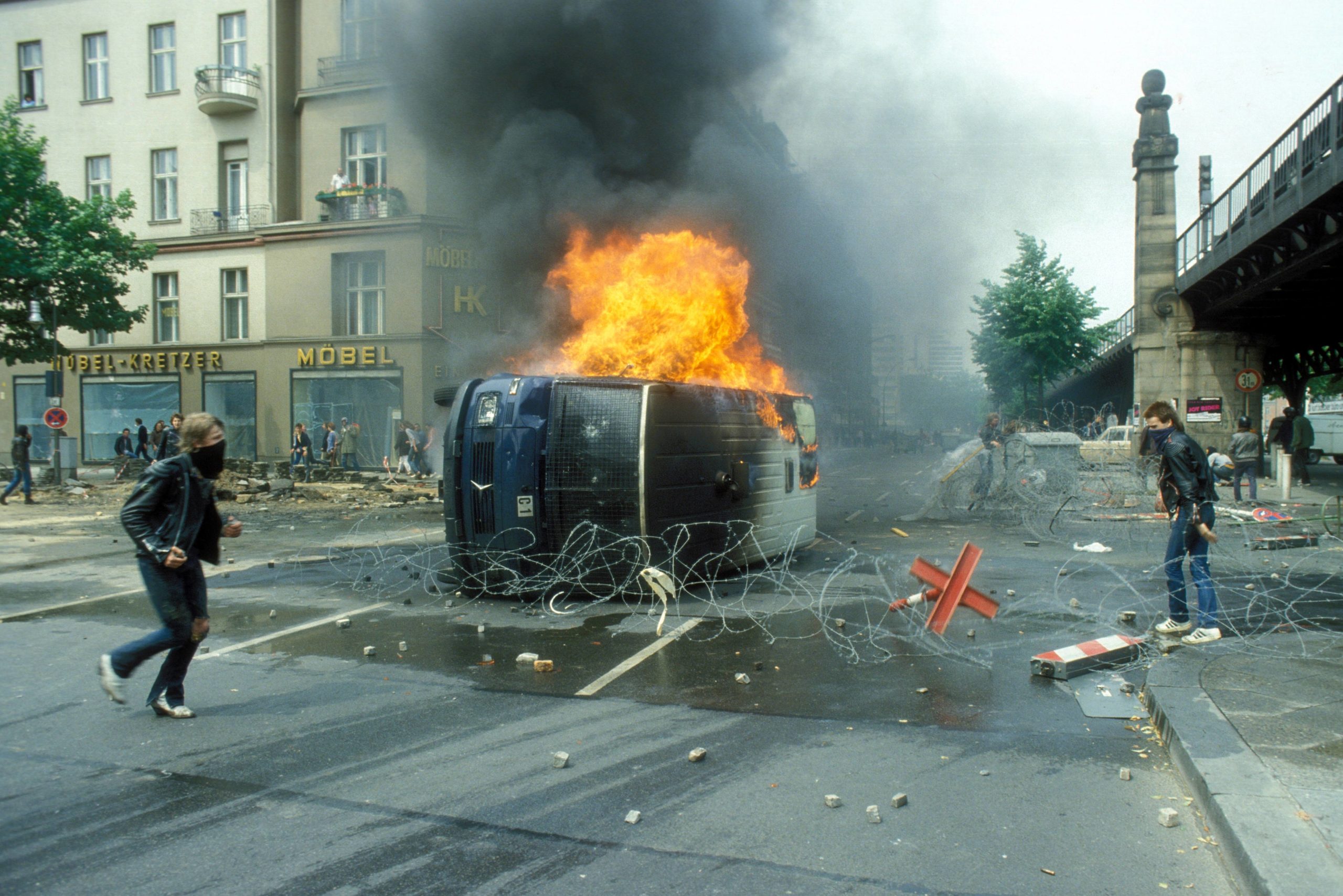 Brennendes Polizeifahrzeug während der Demonstration gegen den Besuch des US-Präsidenten Ronald Reagan in West-Berlin, 11. Juni 1982. Foto: Imago/Sommer