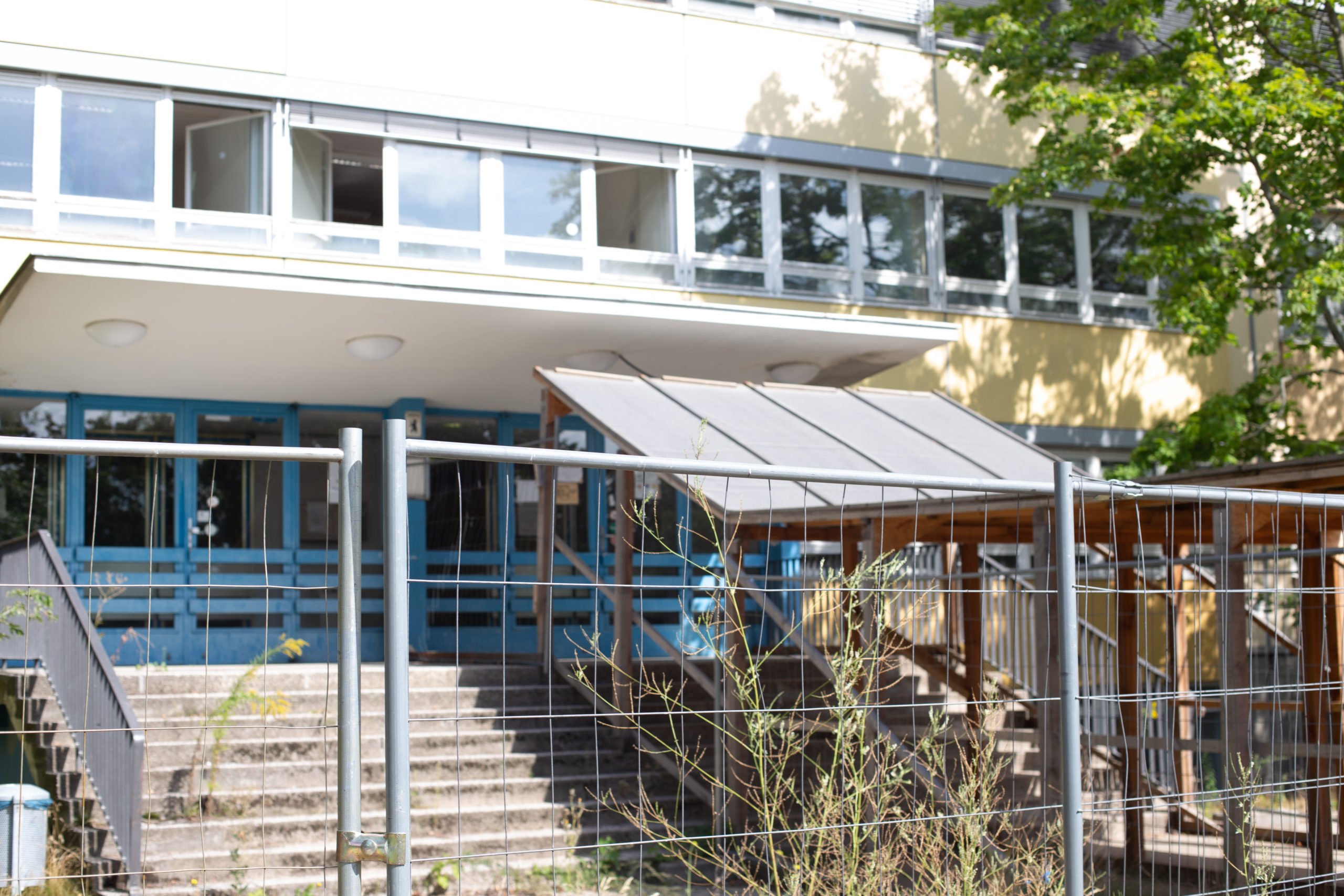 Marode Berliner Schule: Gymnasium am Europasportpark mit Schutzüberdachung und Bauzaun-Absperrung. Foto: Luka Godec