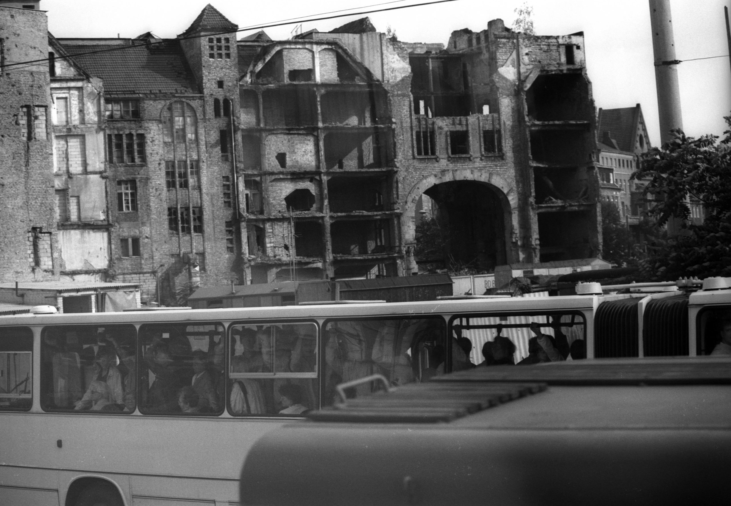Vollgepackter Bus auf der Friedrichstraße und dahinter die Rückseite des Tacheles, 1987. Foto: Imago/Dieter Bauer