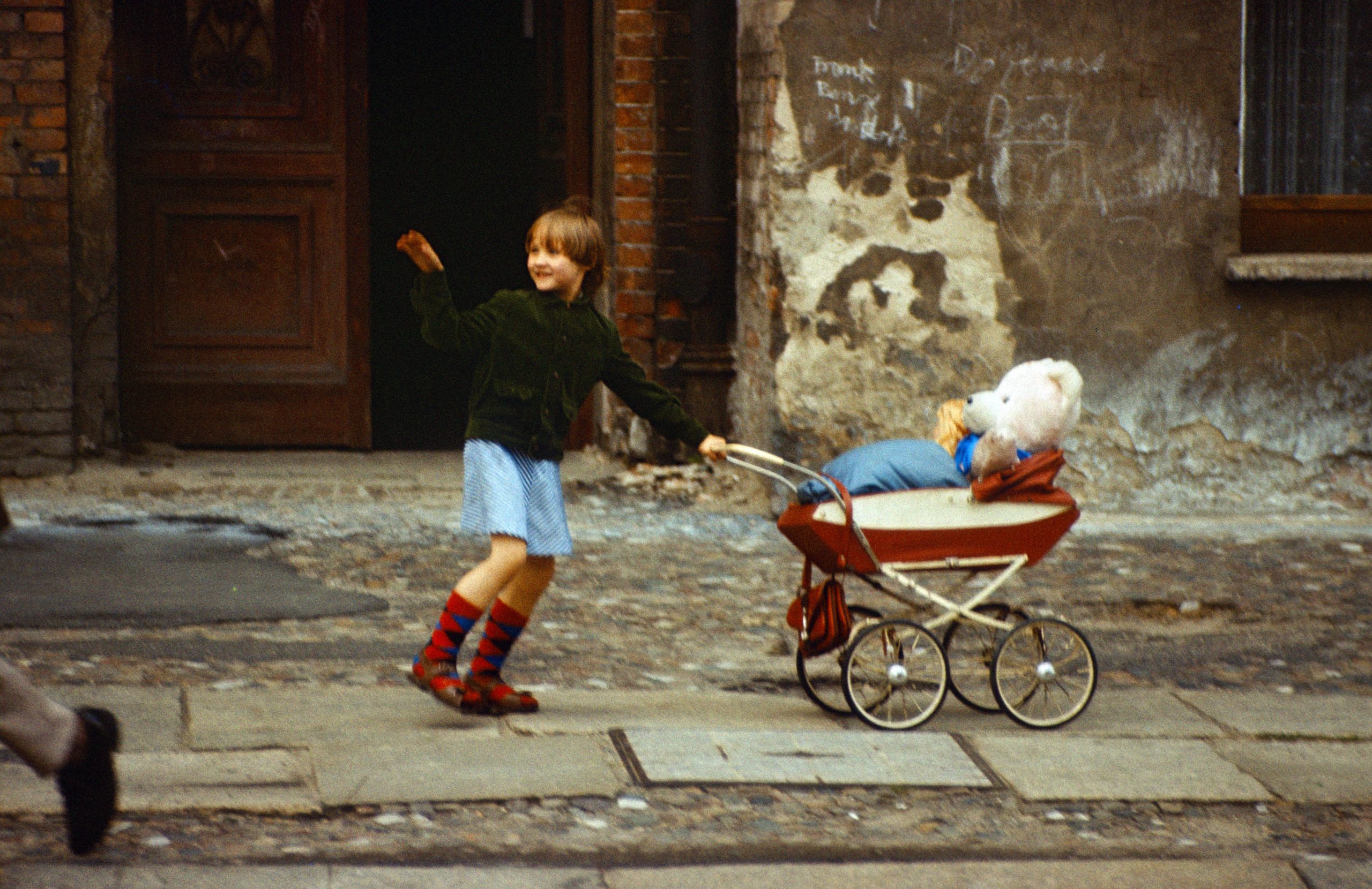 Eine schöne Kindheit in Ost-Berlin... Mädchen schiebt ihren Teddybär in einem Puppenwagen. Foto: Imago/Frank Sorge