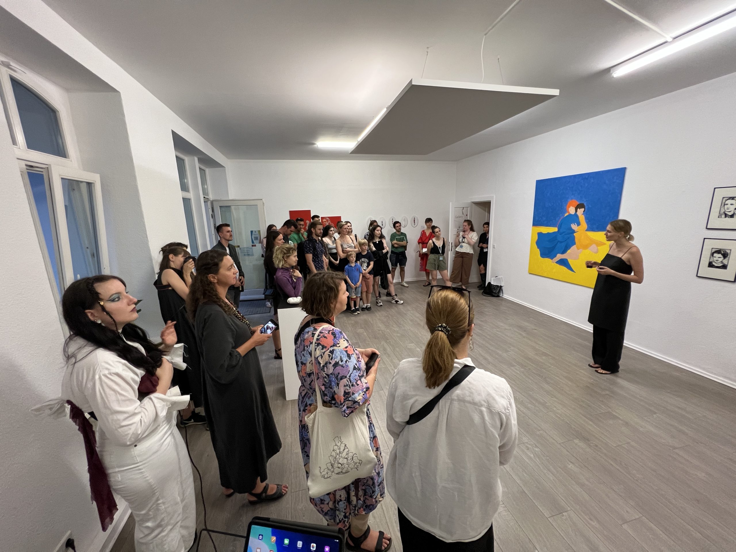 Olha Lobazova spricht zu Besucher:innen während der Ausstellungseröffnung "Light Conquers Darkness" in der Green Hill Gallery.  Foto: Greenhill Gallery