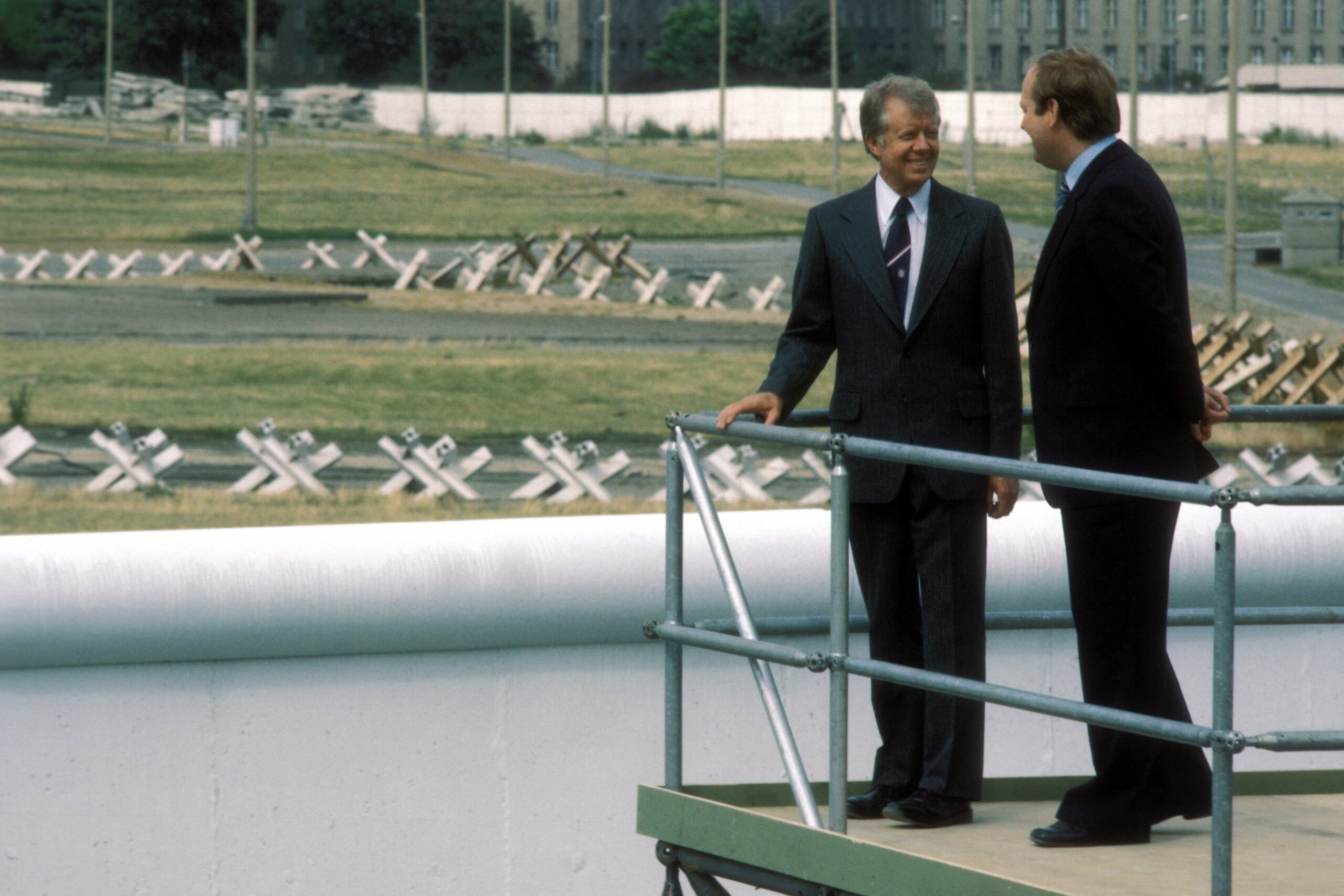 US-Präsident Jimmy Carter und Dietrich Stobbe (Regierender Bürgermeister) betrachten den Todesstreifen auf einer Plattform an der Berliner Mauer am 13. Juli 1978. Foto: Imago/Sven Simon