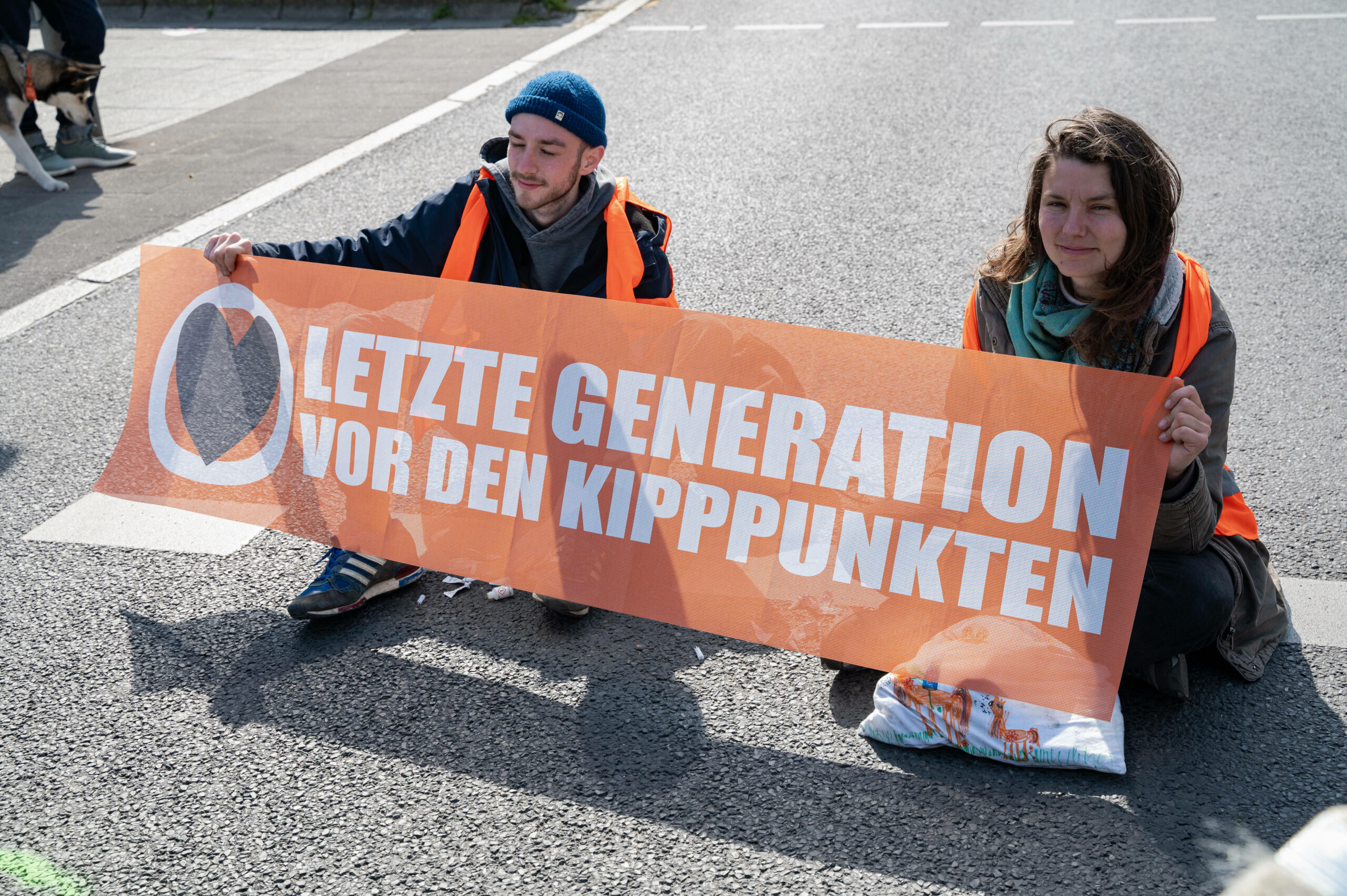 Klimademonstranten der "Letzten Generation" kleben auf der Fahrbahn einer Hauptstrasse und verursachen schwere Verkehrsbehinderungen, April 2023. Foto: Imago/Olaf Schuelke