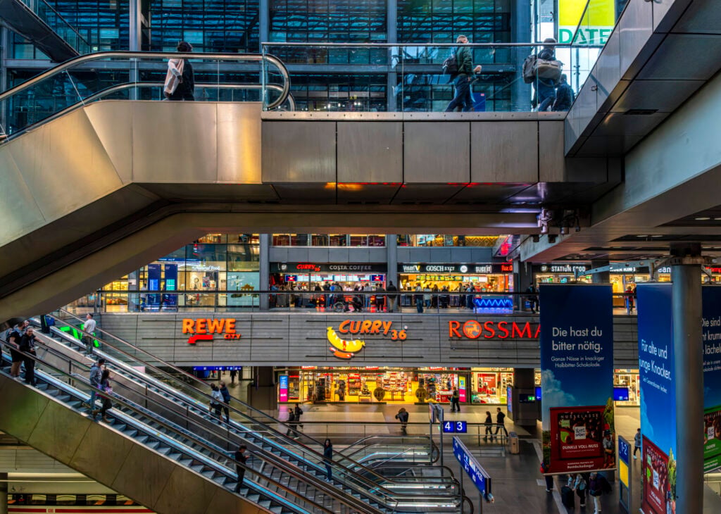 Hauptbahnhof in Berlin mit mehreren Ebenen und Rolltreppen. Im Fokus stehen die bekannten Einzelhandelsgeschäfte REWE, Curry 36 und Rossmann, die von zahlreichen Besuchern frequentiert werden. Die Architektur ist geprägt von klaren Linien und einer funktionalen Gestaltung, Berlin, Deutschland *** Central Station in Berlin with several Levels and Escalators at Focus Standing the known Retail shops REWE, Curry 36 and Rossmann, the from numerous Visitors frequented become the Architecture is coined from clear Lines and a functional Design, Berlin, Germany 1020928691